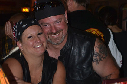 Man and woman smile for the camera while sitting inside.