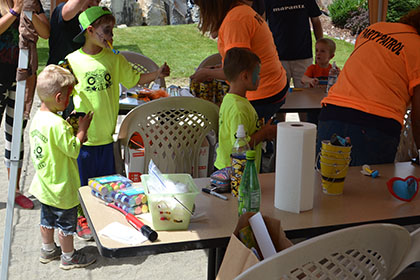 Children and adults gather under a tent at the event.