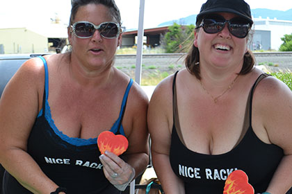 Two women holding heart shaped cookies.