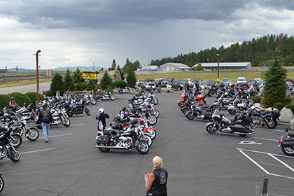 Motorcycles and vehicles in the parking lot at the event.