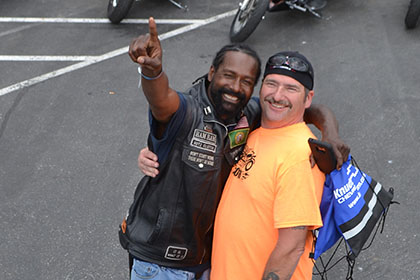 Bearded man and Ride for Life volunteer smile for the camera.