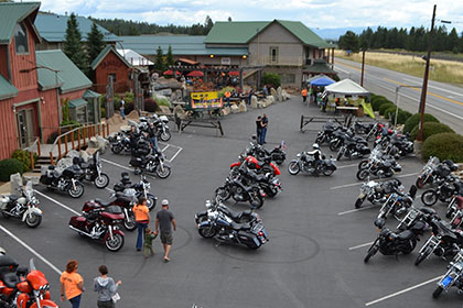 Some people and motorcycles in the parking lot.