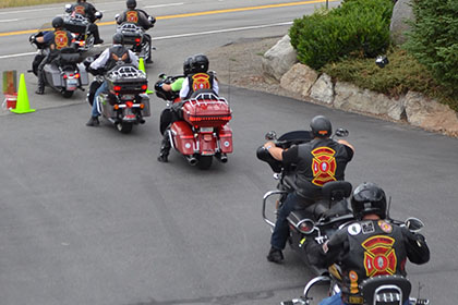 Riders form a line with their motorcycles.