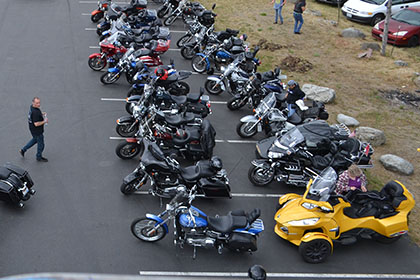 Overview of the parking lot with motorcycles and vehicles.