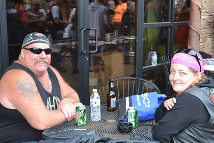 A man and woman sitting at a table outside.