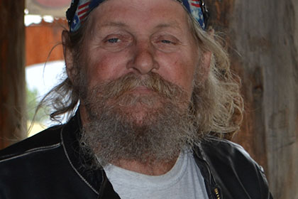 Bearded man with sunglasses and bandana.