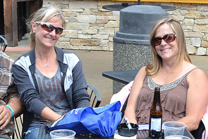 Four people sitting at a table outside.