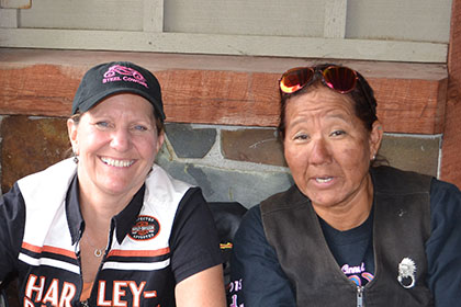 Three people sitting at an outside table.