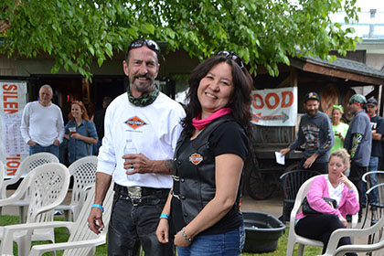 Smiling people standing and sitting on the grass.