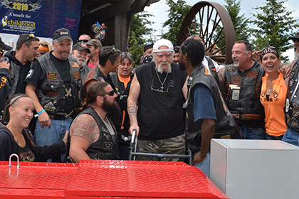 Group of people next to motorcycle lift.