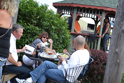 People standing and sitting at outside tables.