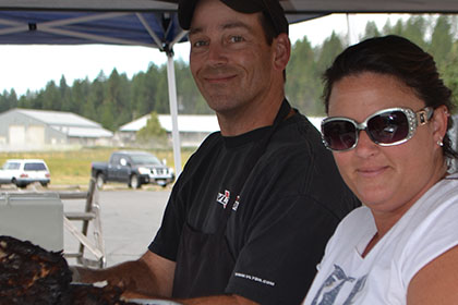 A man and woman under a tent at the barbecue.