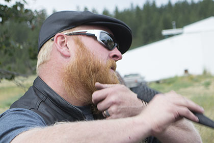 Man combs his beard.