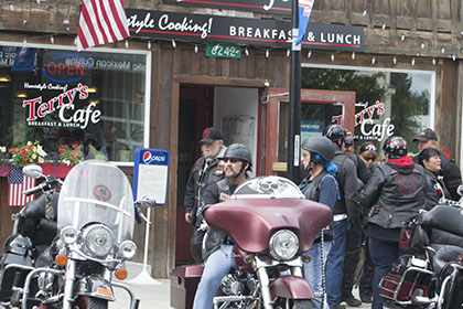 Group of riders standing behind their parked motorcycles.