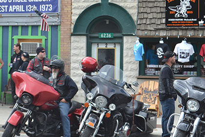 Riders with their motorcycles parked.