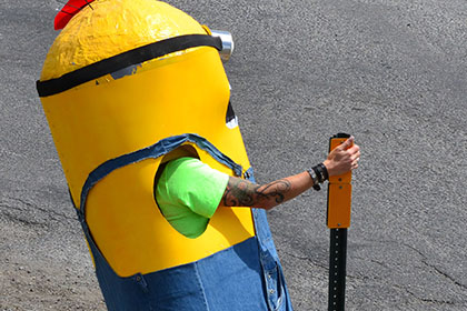 Person dressed as a Minion standing on side of the road.