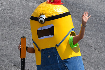 Person dressed as a Minion waves to the camera.