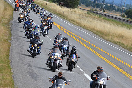 Riders form two long rows while riding on the road.