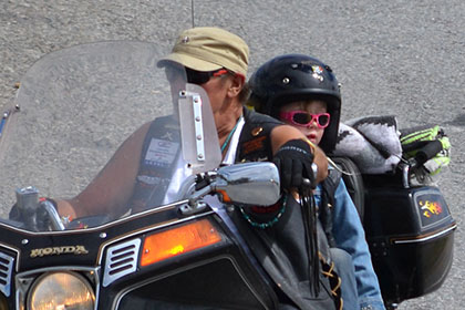 Adult and child on a motorcyle.