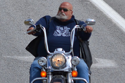 Bearded man riding his motorcyle.